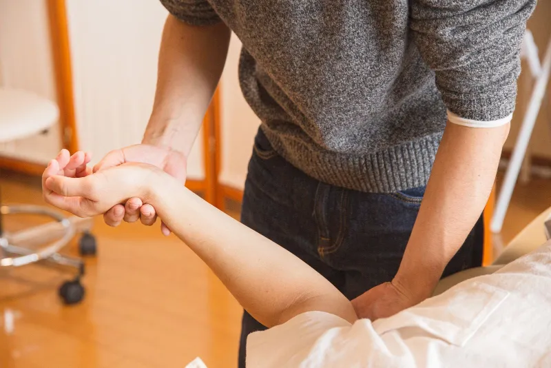 Fisioterapeuta atendendo um paciente na maca